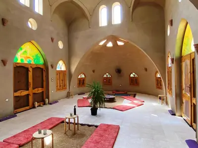 a large room with arches and tables and red rugs at Embrace Hotel in Luxor