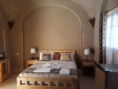 a bedroom with a large bed with two towels on it at Embrace Hotel in Luxor