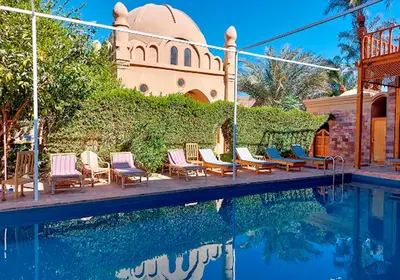 a group of chairs sitting next to a swimming pool at Embrace Hotel in Luxor