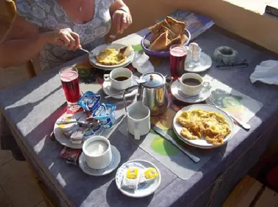 a woman sitting at a table with plates of food at El Nakhil Hotel in Luxor