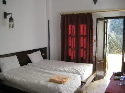 a bedroom with a bed and a red curtain at El Nakhil Hotel in Luxor
