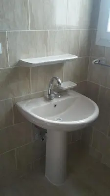a white sink in a tiled bathroom at tiba resort hurghada A16 in Hurghada