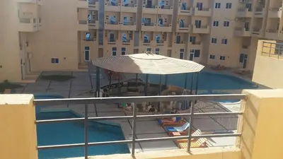 a view of a swimming pool with an umbrella at tiba resort hurghada A16 in Hurghada