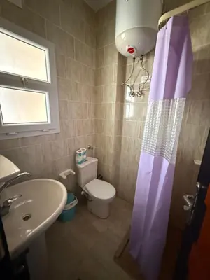 a small bathroom with a toilet and a sink at Cozy little studio near Kite station. in Hurghada