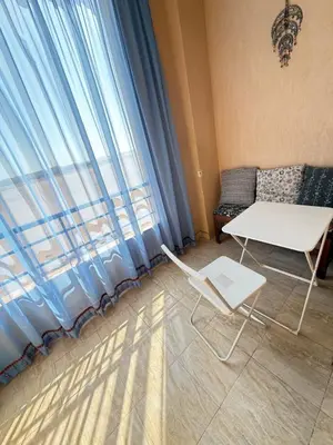 a room with a table and a chair and a window at Cozy little studio near Kite station. in Hurghada