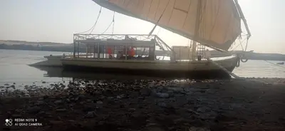a boat sitting on the shore of the water at felouque avec toilettes in Aswan