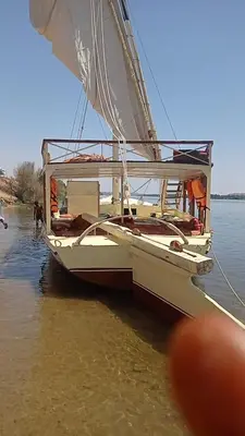 a white sail boat sitting on the water at felouque avec toilettes in Aswan