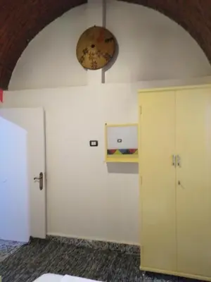 a room with a door and a clock on the wall at Meshra Katto in Aswan
