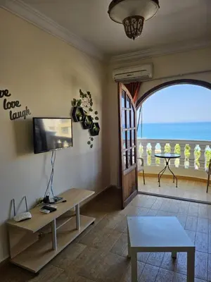 a living room with a television and a view of the ocean at absolute sea view flatS in Hurghada