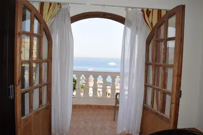 an open door to a balcony with a view of the ocean at absolute sea view flatS in Hurghada