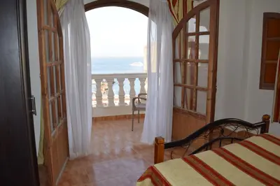 a bedroom with a bed and a view of the ocean at absolute sea view flatS in Hurghada