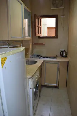 a small kitchen with a sink and a refrigerator at absolute sea view flatS in Hurghada