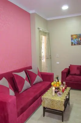a living room with a red couch and a table at Apartments Desert rose near the sea RedSeaLine in Hurghada