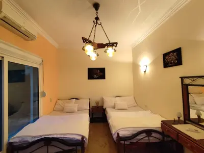 two beds in a room with a chandelier at Villa Rayan in Hurghada