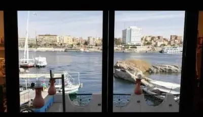 two windows with a view of a harbor with boats at El-amin Guest House in Aswan