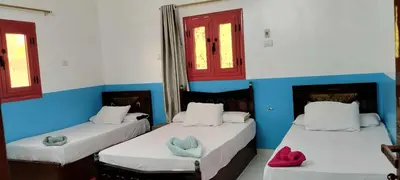 two beds in a room with blue and white walls at El-amin Guest House in Aswan