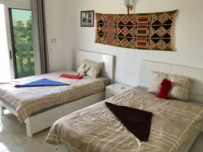 a bedroom with two beds and a flag on the wall at Luxor VIP Apartments in Luxor