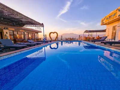 a large swimming pool with chairs and a hotel at Thebes Hotel in Luxor