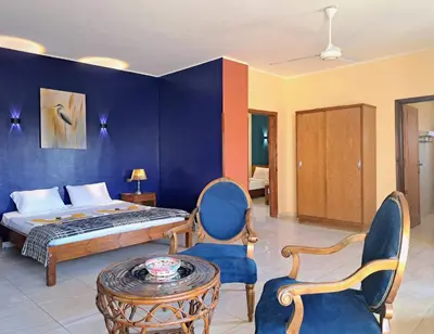 a bedroom with a bed and a table and chairs at Thebes Hotel in Luxor
