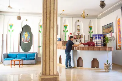 two men are standing at a counter in a room at Thebes Hotel in Luxor