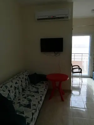 a living room with a couch and a table and a television at Tiba Resort AA in Hurghada