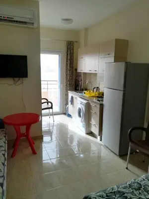 a kitchen with a white refrigerator and a red stool at Tiba Resort AA in Hurghada