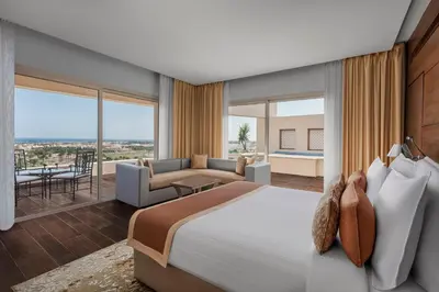 a bedroom with a large bed and a living room at Steigenberger Makadi - Adults Friendly 16 Years Plus in Hurghada