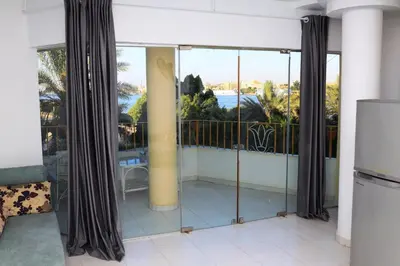 a balcony with glass doors with a view of the ocean at Spring Hotel Luxor in Luxor