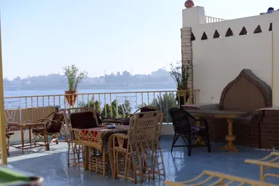 a patio with chairs and tables and a grill at Spring Hotel Luxor in Luxor