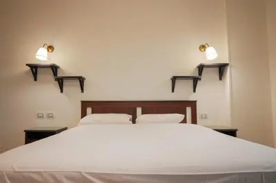a bedroom with a white bed and two lights on the wall at Andalusia Blue Beach Hurghada in Hurghada