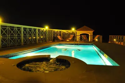 a large swimming pool at night with at Lilly Apartments in Hurghada