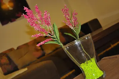a vase with pink flowers in it on a table at Lilly Apartments in Hurghada