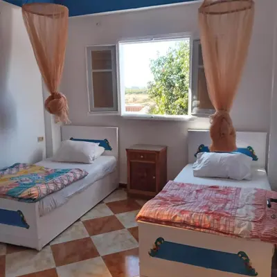 a bedroom with two beds and a window at Adam and Eve House in Luxor