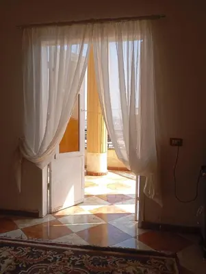 an open door with curtains in a room at Adam and Eve House in Luxor