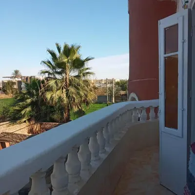 a balcony with a view of a palm tree at Adam and Eve House in Luxor