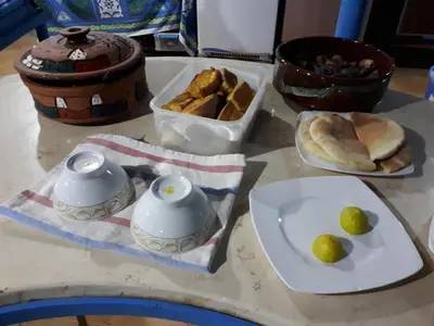 a table with bowls and plates of food on it at Bet El Kerem Guesthouse in Aswan