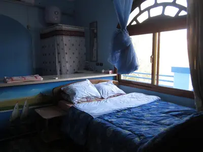 a bed sitting in a room with a window at Bet El Kerem Guesthouse in Aswan