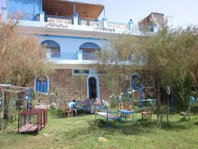 a group of people sitting in a yard in front of a building at Bet El Kerem Guesthouse in Aswan