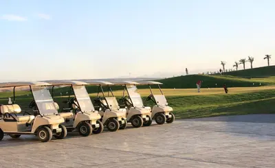 a row of golf carts parked next to a park at JAZ Makadi Saraya Resort in Hurghada