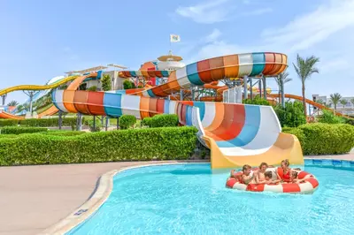 a group of people riding on a water slide at a water park at JAZ Makadi Saraya Resort in Hurghada