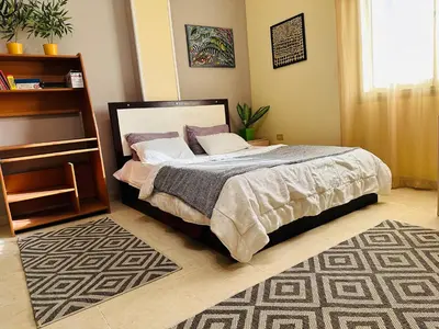 a bedroom with a bed in a room with a rug at Safari Home with Wi Fi Hurghada center in Hurghada