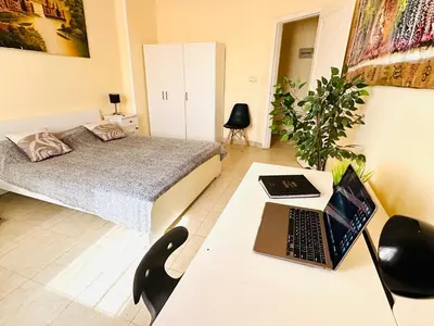a bedroom with a bed and a desk with a laptop at Safari Home with Wi Fi Hurghada center in Hurghada