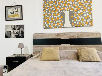 a bedroom with a large bed and a painting on the wall at Lima Modern Sheraton with Wi Fi in Hurghada