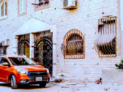 an orange car parked in front of a brick building at Lima Modern Sheraton with Wi Fi in Hurghada