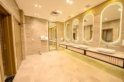 a large bathroom with three sinks and mirrors at Golden Beach Resort in Hurghada