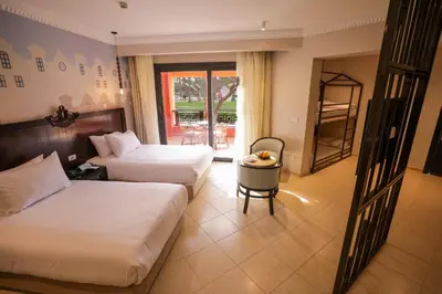 a hotel room with two beds and a table at Calimera Blend Paradise in Hurghada