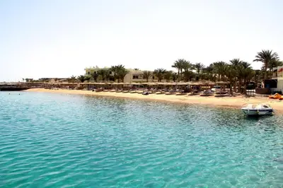 a boat in the water next to a beach at Palm Beach Resort Families and Couples only in Hurghada