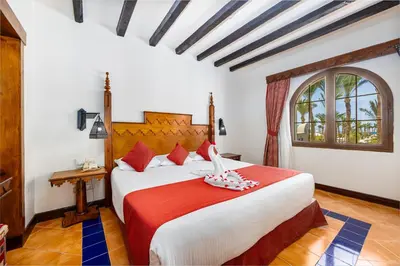 a bedroom with a large bed with a red blanket at Grand Makadi - Couples and Families Only in Hurghada