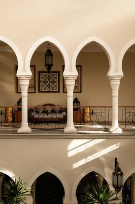 a building with arches and a table and chairs at Grand Makadi - Couples and Families Only in Hurghada