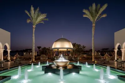a fountain in the middle of a pool with palm trees at Grand Makadi - Couples and Families Only in Hurghada